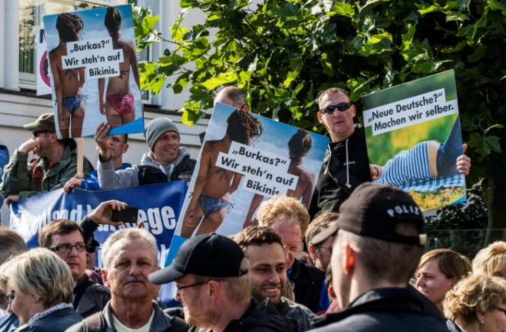 "Burkas? nous préférons les bikinis" et "De nouveaux Allemands? faisons les nous-mêmes", lit-on sur les pancartes de manifestants de l'AfD près d'un meeting élecrtral de Angela Merkel à Binz le 16 septembre 2017