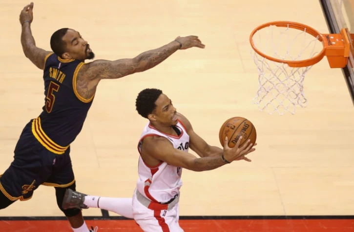 Le jouer de Toronto DeMar DeRozan évite, sous la raquette, J.R. Smith de Cleveland lors du match 3 de la finale de la conférence Est des play-offs NBA, le 21 avril 2016 à Toronto au Canada