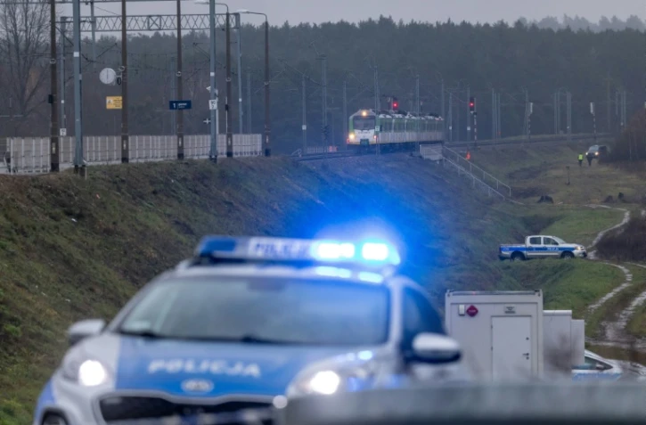 Des véhicules de la police polonaise stationnent aux abords d'une ligne de chemins de fer cible d'un "acte de sabotage", selon Varsovie,  le 17 novembre 2025 à Mika, près de Garwolin (centre).