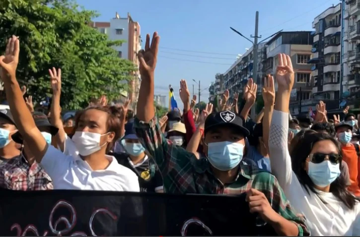 Sur cette capture d'écran d'une vidéo  AFPTV, des manifestants font le salut à trois doigts, signe de ralliement de la contestation, le 2 mai 2021 à Rangoun