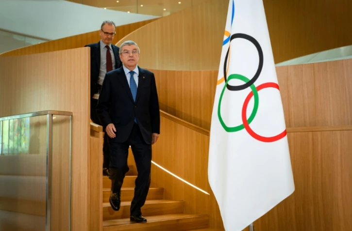 Thomas Bach, le président du Comité intrernatikonal olympique, suivi par le porte-parole de l'instance Mark Adams le 3 mars 2020 au siège de l'instance à Lausanne