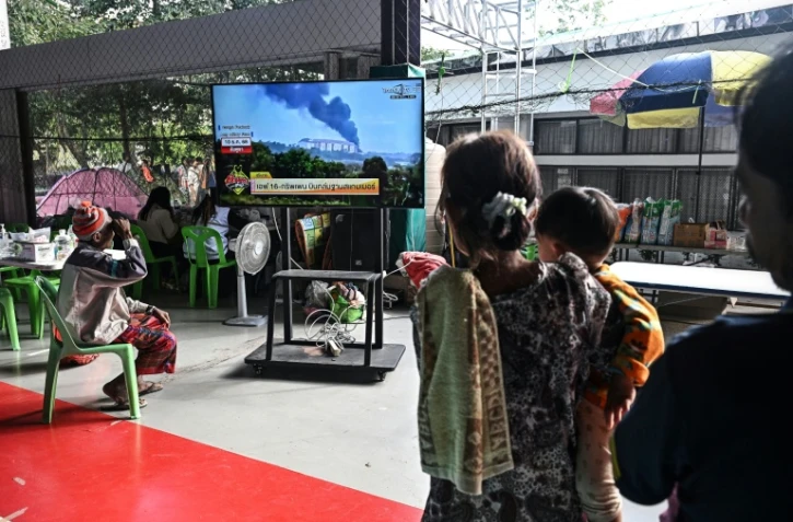Des personnes déplacées par les combats à la frontière aavec le Cambodge regardent les informations à la télévision dans un centre pour évacués dans la province thaïlandaise de Surin, le 11 décembre 2025