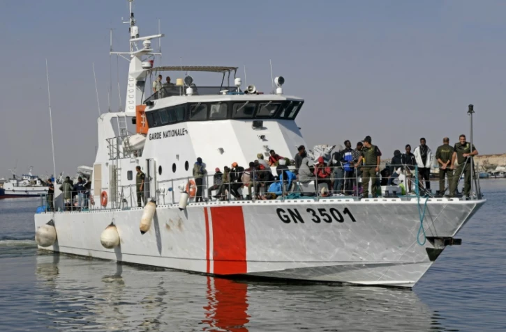 Des migrants secourus en mer arrivent dans le port de Sfax à bord d'un bateau de la Garde nationale tunisienne, le 4 octobre 2022