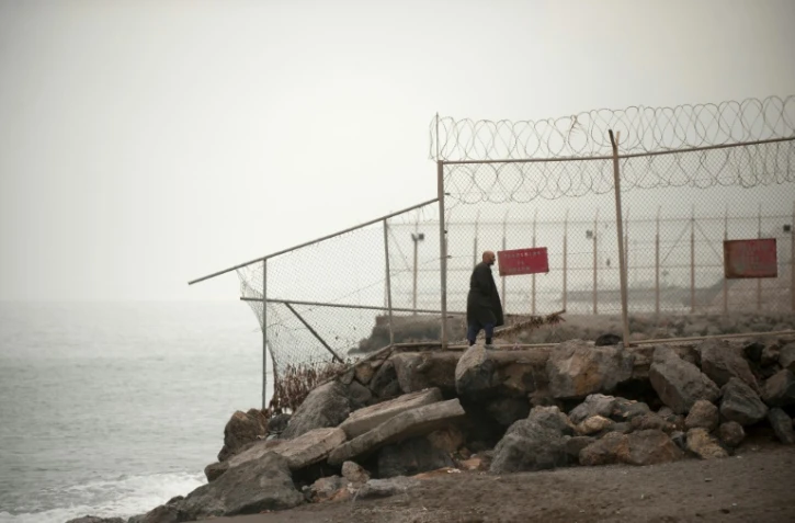 Un homme le long de la clôture séparant le Maroc de l'enclave espagnole de Ceuta, le 27 octobre 2016