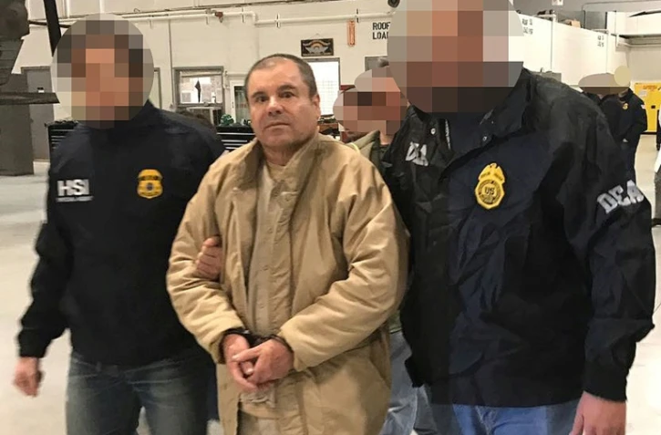 Le Mexicain Joaquin Guzman Loera dit "El Chapo" à Ciudad Juarez lors de son extradition vers les Etats-Unis, selon une photo divulguée le 19 janvier 2017 par le ministère mexicain de l'Intérieur, qui a flouté le visage de ses deux policiers