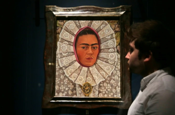 Un employé du musée Victoria & Albert Museum de Londres devant un autoportrait de Frida Kahlo lors d'une exposition consacrée à l'artiste mexicaine, le 13 juin 2018
