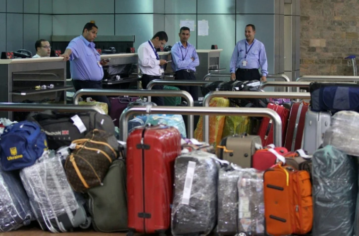 Le personnel egyptien de l'aéroport de Charm el-Cheikh près des bagages dans le terminal des départs le 5 novembre 2015