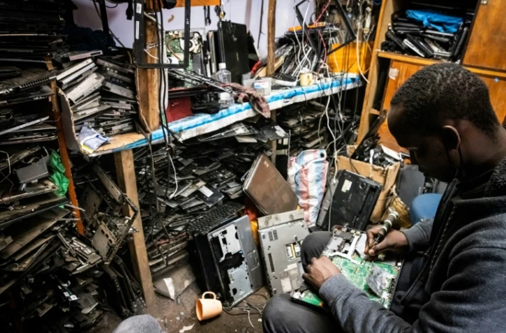 Un membre de l'ONG locale Electronic Waste Initiative Kenya (E-WIK) répare une carte-mère dans un atelier à Nairobi, au Kenya, le 3 décembre 2021