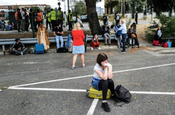 Une passagère attend devant l'aéroport de Toulouse-Blagnac, en Haute Garonne, le 18 octobre 2023, après une alerte à la bombe qui a perturbé les vols