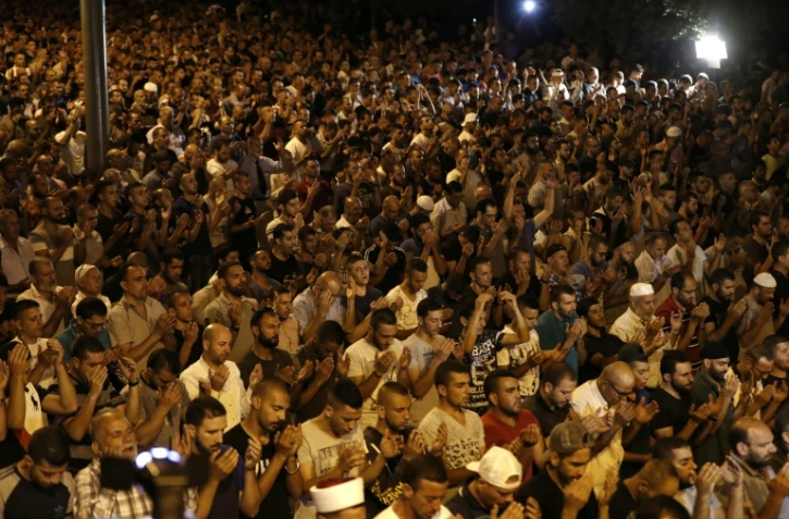 Des Palestiniens musulmans prient aux abords de l'esplanade des Mosquées, le 23 juillet 2017, en protestation contre les nouvelles mesures sécuritaires israéliennes 