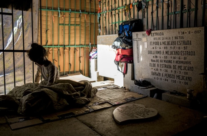 Une fillette se repose dans un abri de fortune dans le cimetière de Caracas, le 10 février 2021