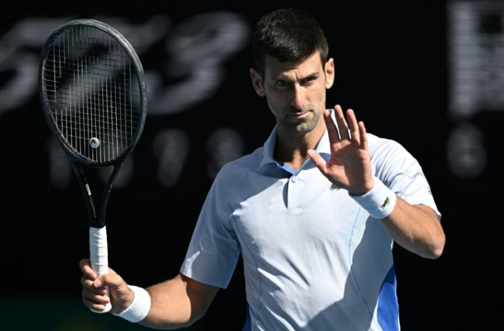 Novak Djokovic réagit lors d'un match contre l'Italien Jannik Sinner, le 26 janvier 2024 à Melbourne en Australie