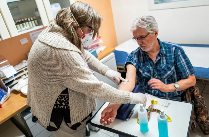 Le docteur Ulrike Leimer-Lipke pratique un test sérologique sur Lothar Kopp dans une clinique de Berlin le 7 avril 2020