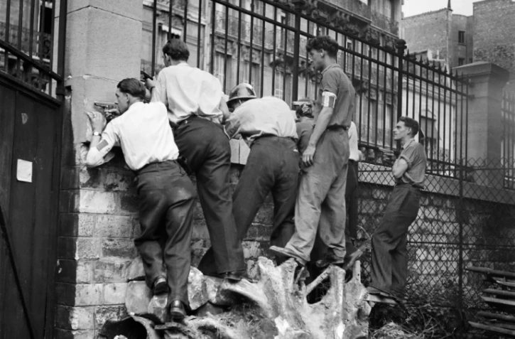 Des membres des FFI (Forces françaises de l'intérieur) font le guet derrière un mur, Paris est encore occupé
