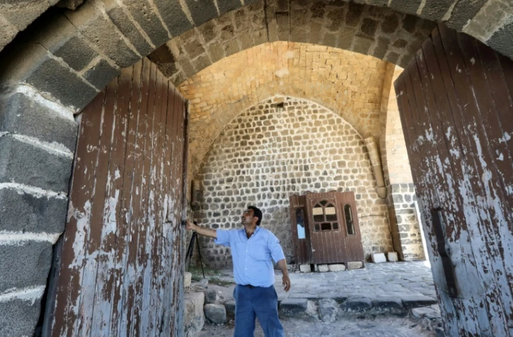 Le gardien Younes Dayoub ouvre les portes de la citadelle Al-Marqab, le 25 juillet 2022 près de Banias, dans l'ouest de la Syrie 