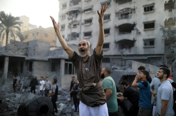Un Palestinien lève les bras en criant après une frappe israélienne à Khan Younès dans le sud de la bande de Gaza, le 14 octobre 2023