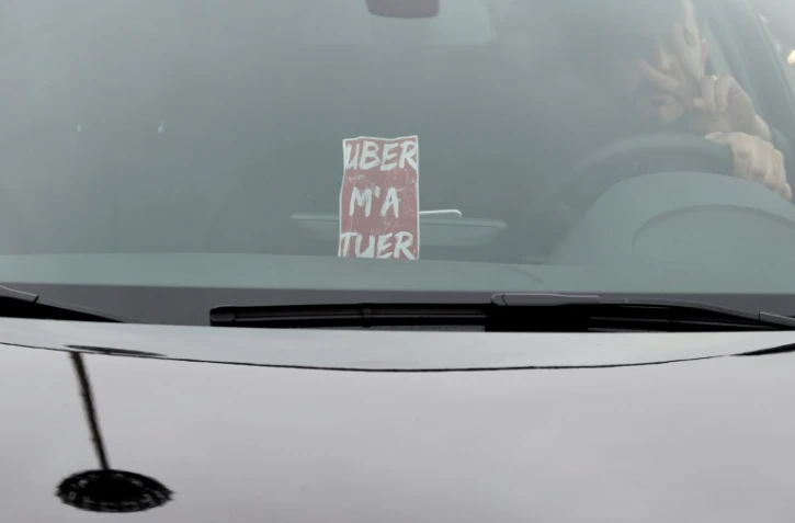 Des chauffeurs travaillant pour Uber manifestent contre les baisses de prix imposées par la plate-forme de réservation place de la Porte Maillot à Paris le 18 décembre 2015