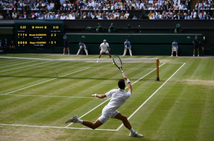 Le Serbe Novak Djokovic (au premier plan) lors de la dernière finale messieurs de Wimbledon qu'il a remportée face au Suisse Roger Federer le 14 juillet 2019 à Londres. 