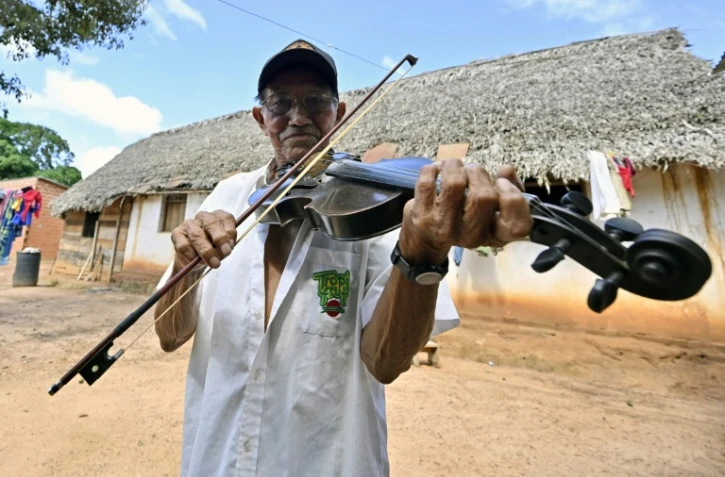 Le luthier Hildeberto Oreyai joue du violon devant sa maison à Urubichá, en Bolivie, le 22 avril 2024