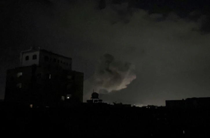 Une capture d'écran d'une vidéo de l'AFPTV montre une colonne de fumée au dessus de Sanaa, le 15 mars 2025