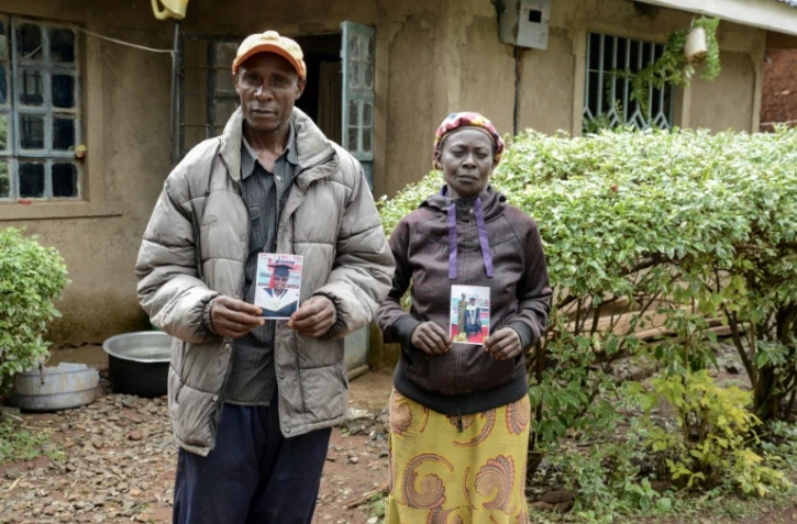 Moses Muyela et Josephine Ngoya, les parents d'Erastus Mundia, montrent des photos de leur fils, chez eux à Nabemo, au Kenya, le 27 février 2026