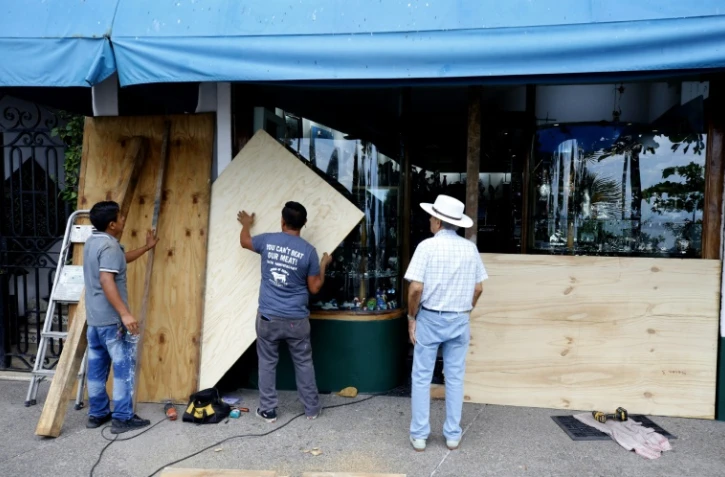 Des commerçants barricadent la devanture de leurs magasins en prévision de l'arrivée de l'ouragan Lidia, le 10 octobre 2023 à Puerto Vallarta, au Mexique
