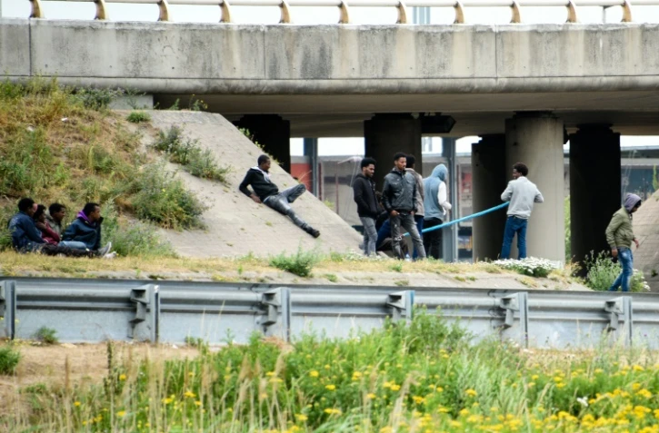 Des migrants au bord d'une route près du Port de Calais, dans les Hauts-de-France, le 3 juillet 2017