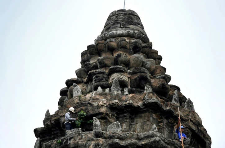 Un jardinier enlève des pousses d'arbre sur le temple d'Angkor Wat, le 12 octobre 2020