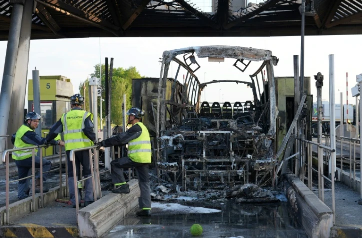 Un autocar calciné après des affrontements entre fans de l'OL et du PSG à un péage d'autoroute, juste avant la finale de la Coupe de France à Lille, le 25 mai 2024 au péage de  Fresnes-lès-Montauban, dans le Pas-de-Calais  