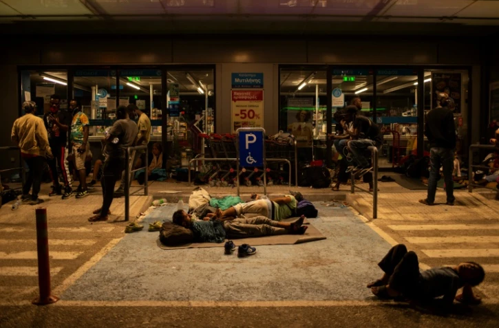 Des migrants devant un supermarché le 10 septembre 2020 à Lesbos (Grèce)