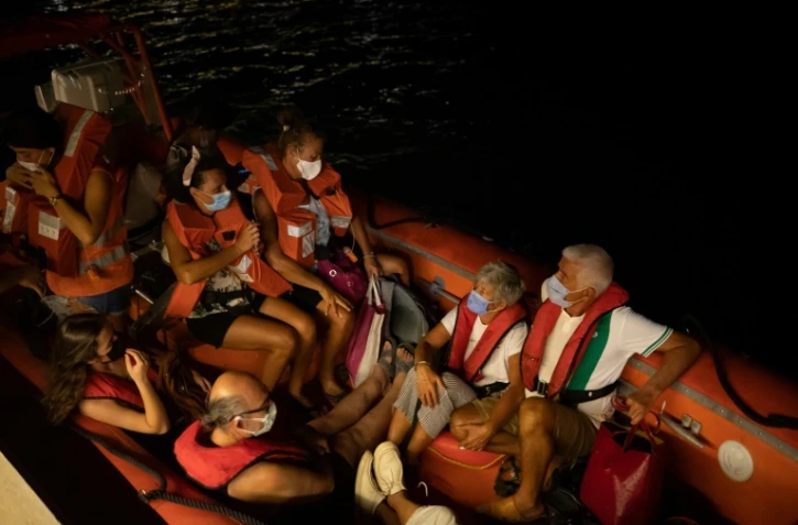 Des villageois sont évacués de Milas, le 4 août 2021  par des garde-côtes turcs pour s'éloigner de l'incendie qui menace la centrale thermique locale