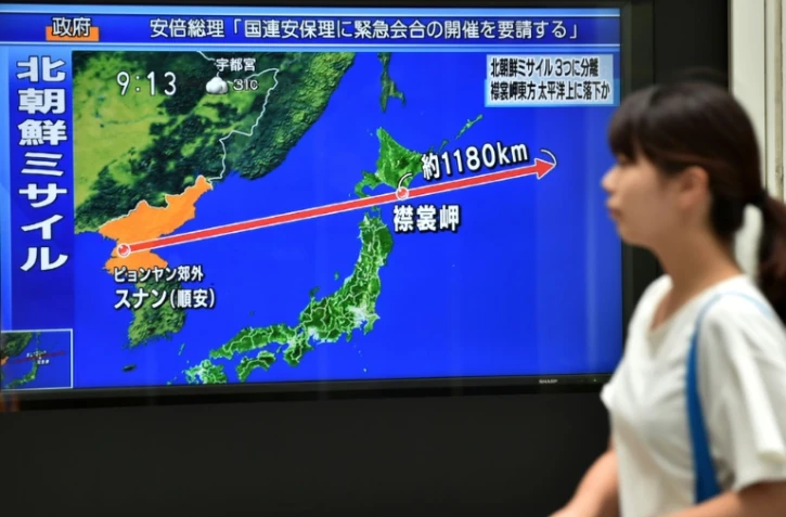 Une carte sur un écran de télévision le 29 août 2017 à Tokyo montre la trajectoire du missile tiré de Corée du Nord et passant au-dessus du Japon 