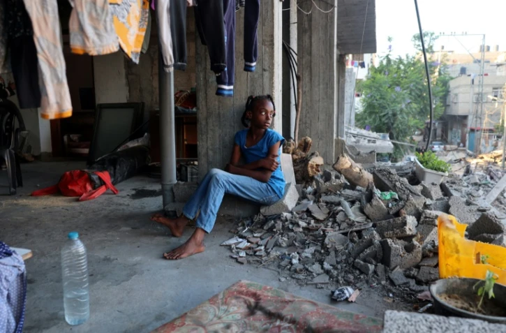 Une fille palestinienne déplacée est assise dans un bâtiment endommagé utilisé comme abri temporaire dans le camp de réfugiés d'al-Bureij dans le centre de la bande de Gaza, le 12 juin 2024