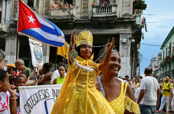 Une fidèle brandit une poupée représentant la Vierge de la Charité, dans la religion catholique, et Oshun dans la religion yoruba, lors de la traditionnelle procession en leur honneur, à La Havane, le 8 septembre 2026