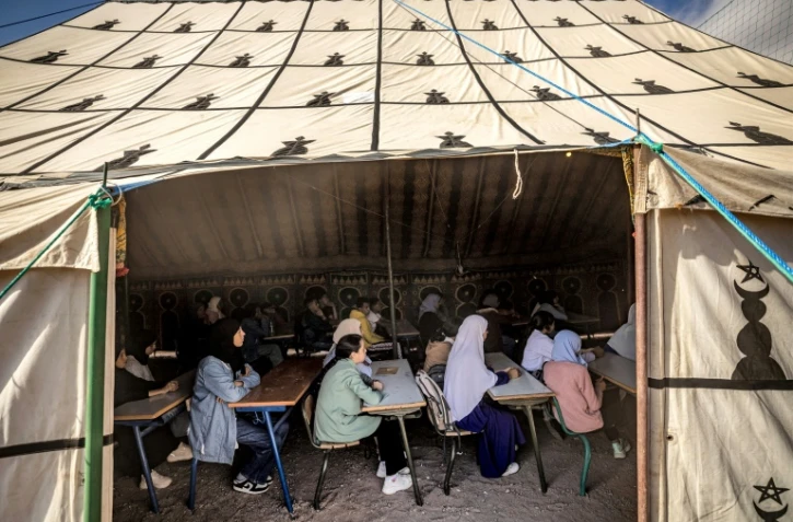 Des élèves suivent des cours sous une tente dans une école de fortune dans le village d'Asni, touché par le tremblement de terre, dans la province d'Al-Haouz, au Maroc, le 18 septembre 2023