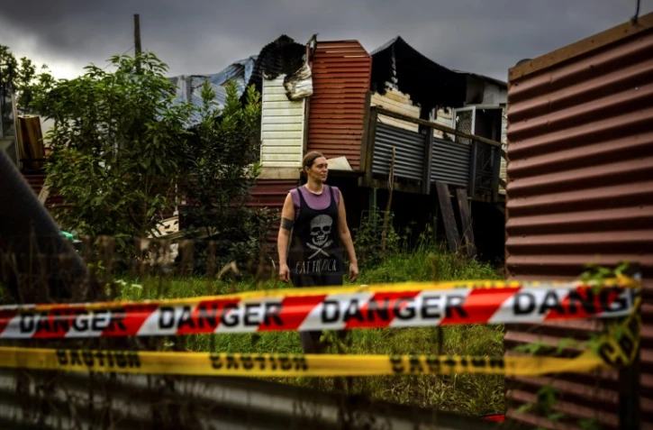 L'Australienne Rahima Jackson, le 15 mai 2022 à Lismore, en Nouvelles Galles du Sud, devant sa maison détruite par les inondations catastrophiques qui ont touché la région trois mois plus tôt