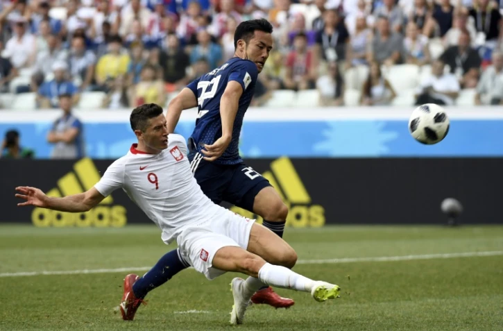 L'attaquant polonais Robert Lewandowski (g) à la lutte avec le défenseur japonais Maya Yoshida, le 28 juin 2018 à Volgograd