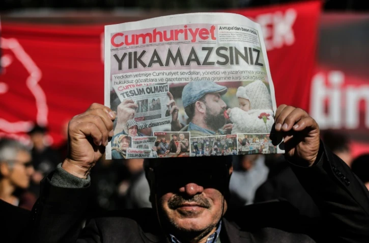 Un manifestant brandit un exemplaire du quotidien d'opposition "Cumhuriyet" devant le siège du journal à Istanbul le 2 novembre 2016