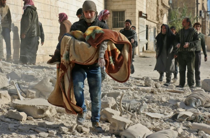 Un Syrien emporte le corps d'un enfant tué dans un bombardement du quartier Bab al-Nairab le 24 novembre 2016 à Alep