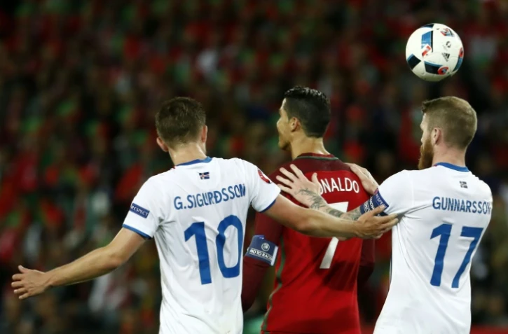 L'attaquant portugais Cristiano Ronaldo, marqué de près par les Islandais Gylfi Sigurdsson et Aron Gunnarsson lors de l'Euro, le 14 juin 2016 à Saint-Etienne