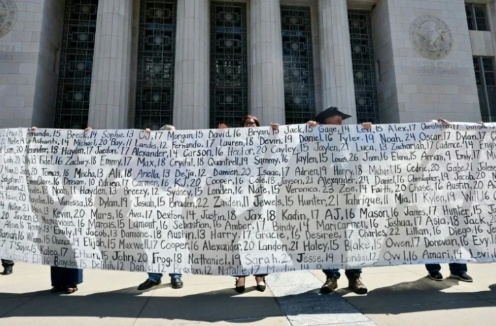 Des parents et des proches tiennent une banderole listant les noms des victimes devant la Cour supérieure de Los Angeles après le verdict du procès concernant les réseaux sociaux, le 25 mars 2026 en Californie