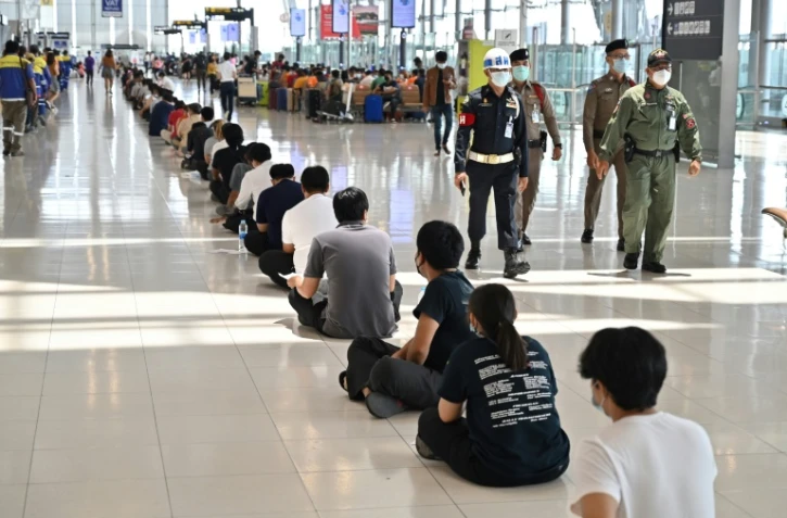 Des personnels de l'aéroport font la queue avant d'être vaccinés contre le covid-19 au terminal départ de l'aéroport Suvarnabhumi à Bangkok le 30 juin 2021
