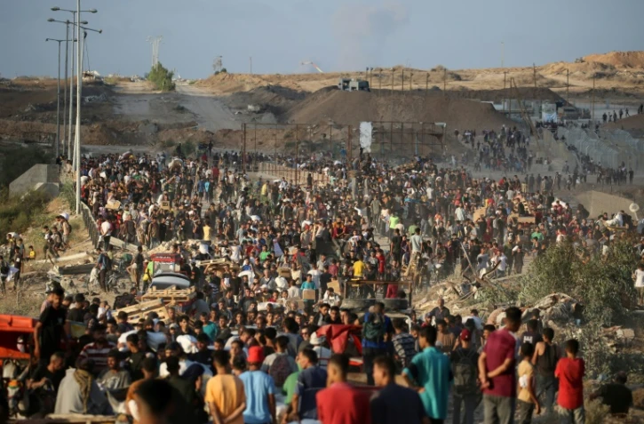 Des Palestiniens rassemblés à un point de distribution d'aide mis en place par la Fondation humanitaire de Gaza (GHF), près du camp de réfugiés de Nousseirat, dans le centre de la bande de Gaza, le 25 juin 2025
