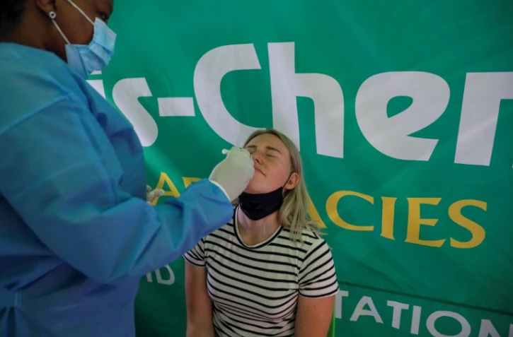 Un agent de santé effectue un test PCR de Covid-19 sur un voyageur à l'aéroport international de Johannesburg le 27 novembre 2021