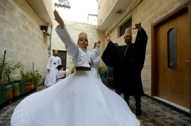 Le derviche tourneur, Mahmoud al-Kharrat (à droite), 34 ans, danse avec d'autres membres de sa famille dans la cour de leur maison dans la vieille ville de Damas, le 6 mai 2021