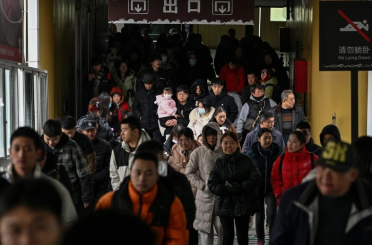 Des voyageurs débarquent d'un ferry, le 22 décembre 2024 dans la ville chinoise de Wuhan, dans la province centrale du Hubei