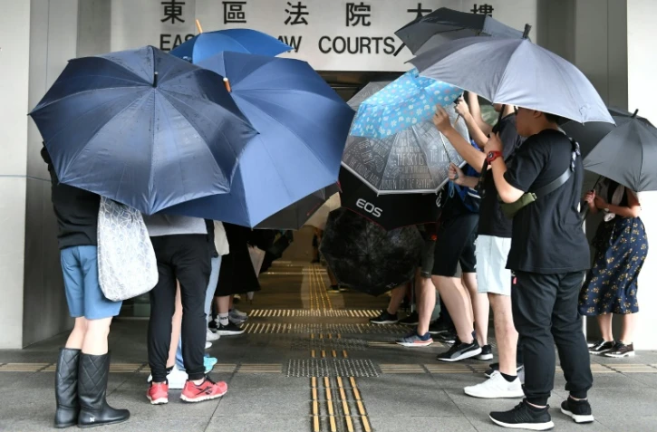 Protesters covered themselves with umbrellas as they gathered outside the Eastern District Courts in Hong Kong
