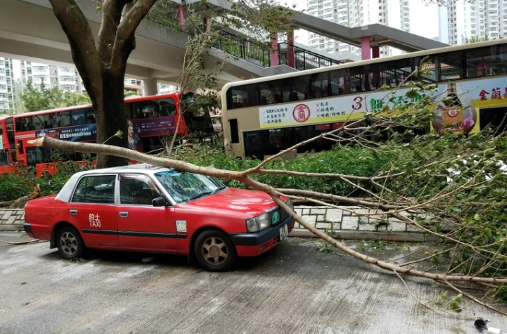 Un taxi endommagé par la chute d'un arbre après le passage du typhon Mangkhut, le 17 septembre 2018 à Hong Kong