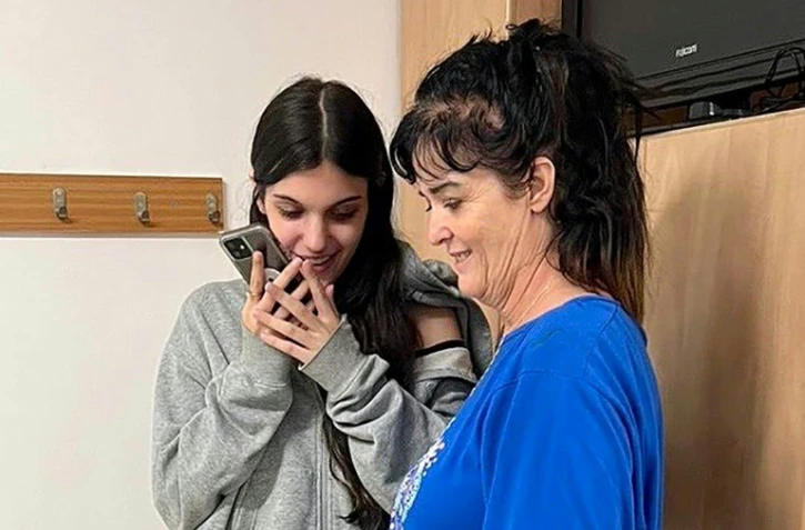 Les Américaines Natalie Shoshana Raanan (à gauche) et sa mère Judith Tai Raanan parlent au téléphone avec le président américain Joe Biden à l'ambassade des Etats-Unis à Jérusalem après leur libération par le Hamas, le 20 octobre 2023