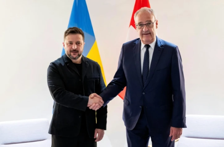 Le président suisse Guy Parmelin (d.) serre la main du président ukrainien Volodymyr Zelensky avant une rencontre bilatérale en marge du sommet du G7, à l'aéroport de Genève, le 15 juin 2026